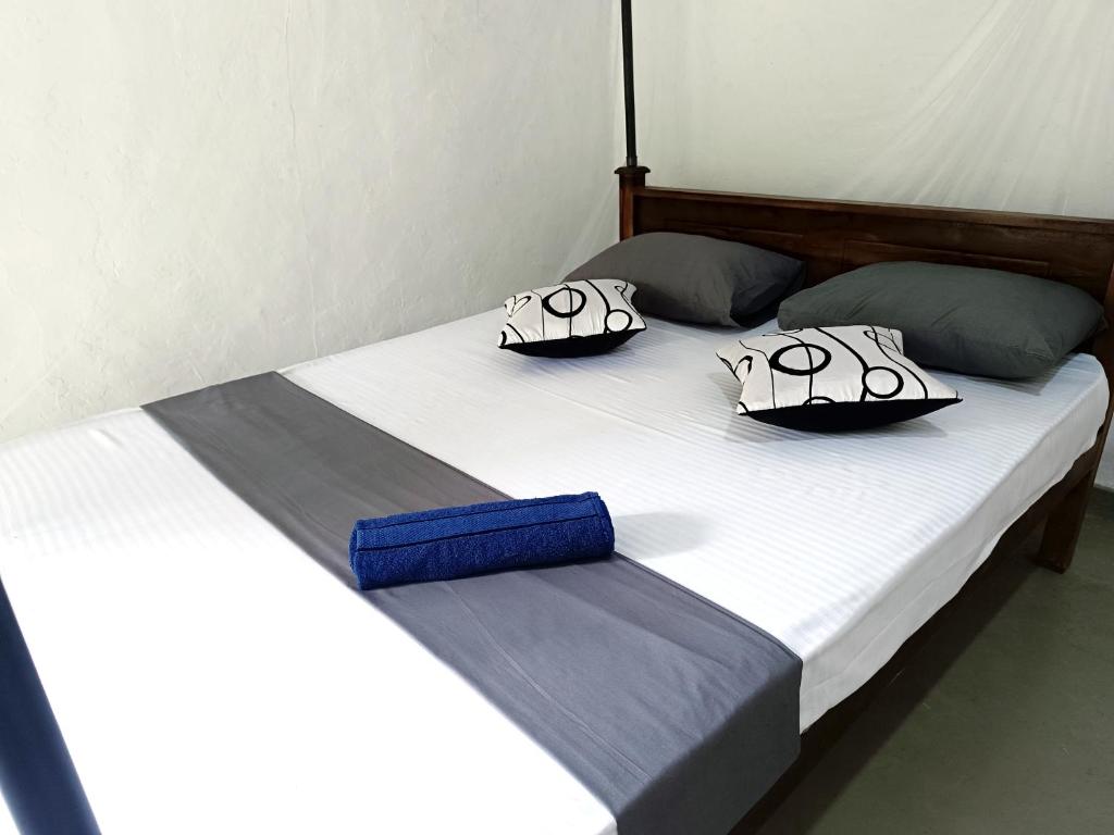Una cama con dos almohadas encima. en The Moon House, en Weligama