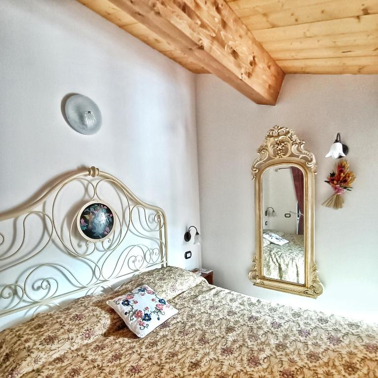a bedroom with a bed and a mirror at Appartamento Augusta - Residenza la Madonina in Morciano di Romagna