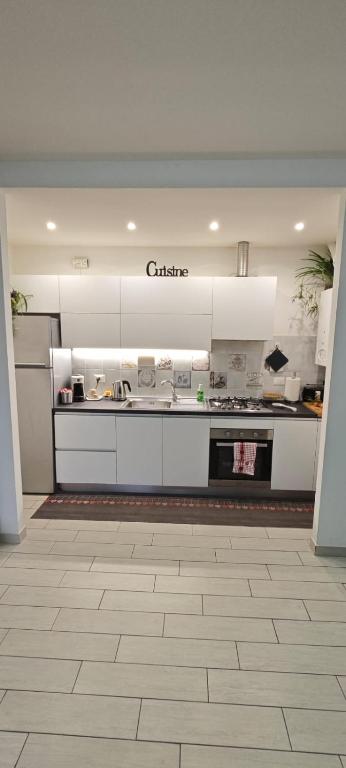 a kitchen with white cabinets and a counter top at Casa Ricci in Acilia