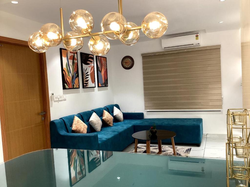 トリバンドラムにあるLuxe Luminar- 1 BHK Apartmentの青いソファとテーブルのあるリビングルーム