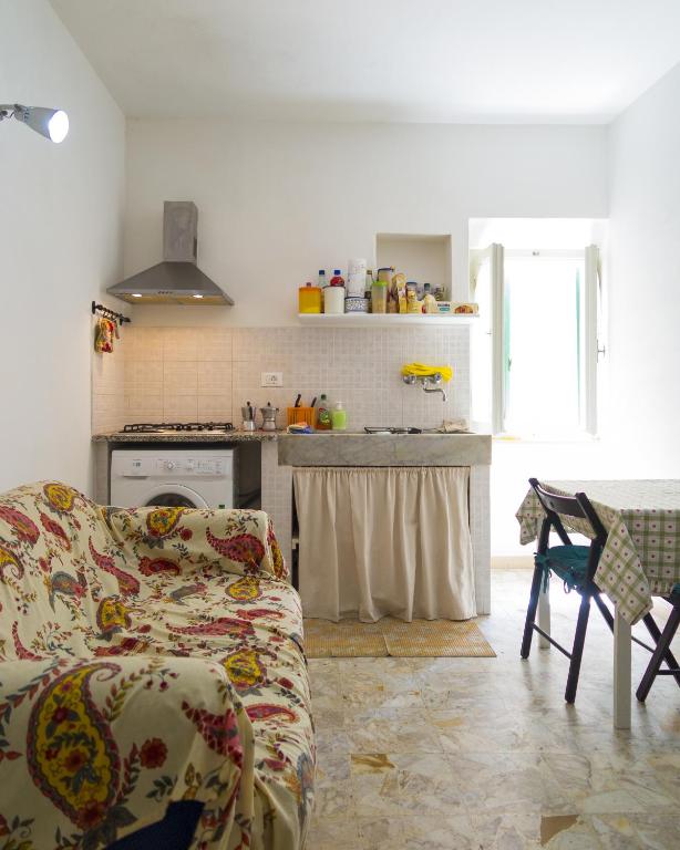a living room with a couch and a kitchen at Appartamenti Dietro L'Angolo in Portoferraio