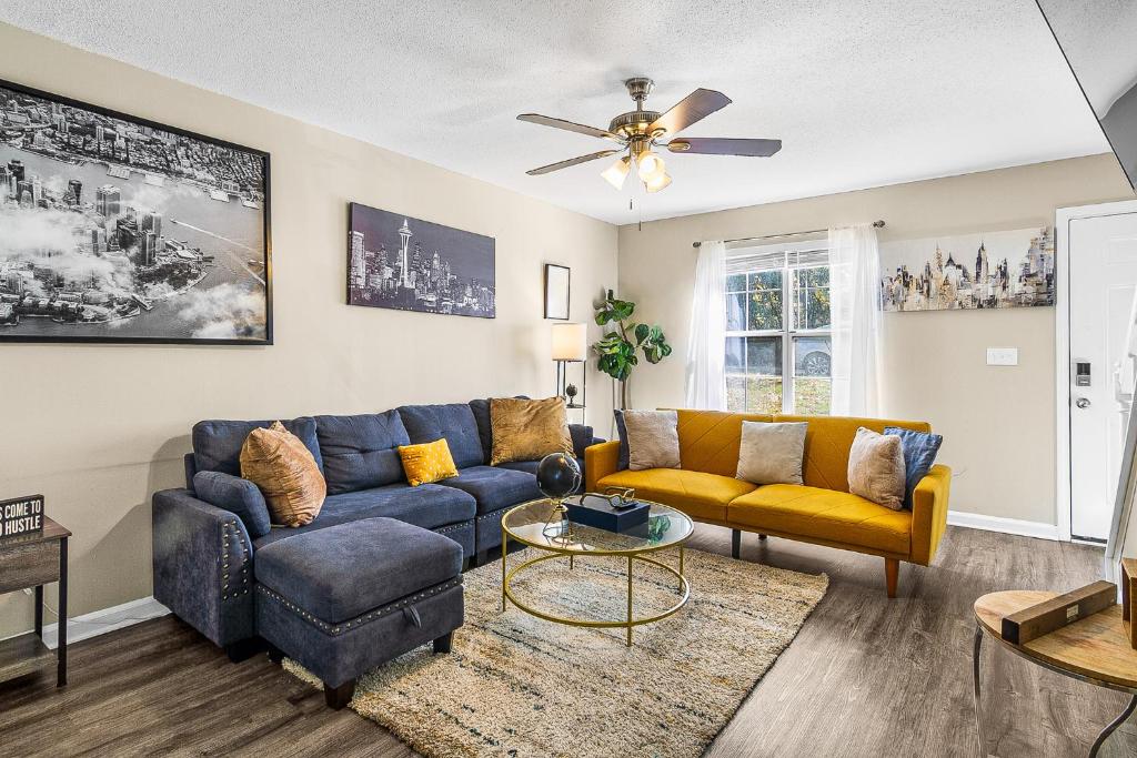 a living room with a blue couch and yellow chairs at Home away from home! Min from the airport and downtown in Atlanta