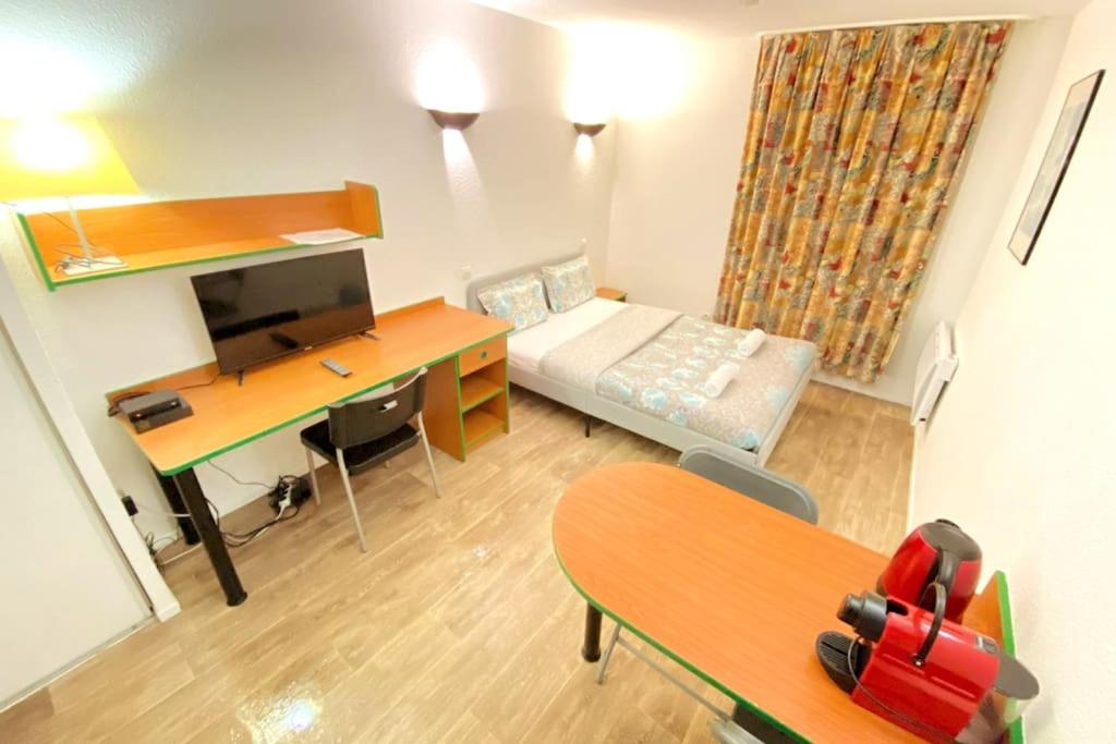 Cette petite chambre comprend un bureau et un bureau. dans l'établissement 10 min walk to metro Line 1, ApartHotel La Défense, à Courbevoie
