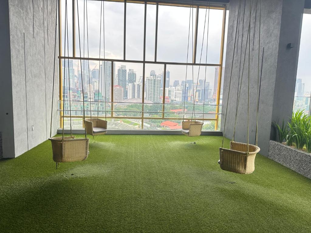 吉隆坡的住宿－Grand Residence Suite At Opus Kuala Lumpur，客房设有大窗户 和绿色地毯。