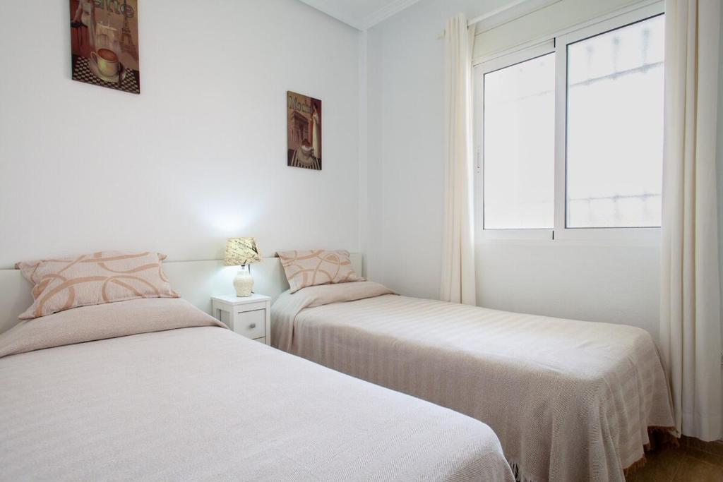 A bed or beds in a room at APARTAMENTO EL PALMERAL LOS NIETOS CERCA DE LA MANGA