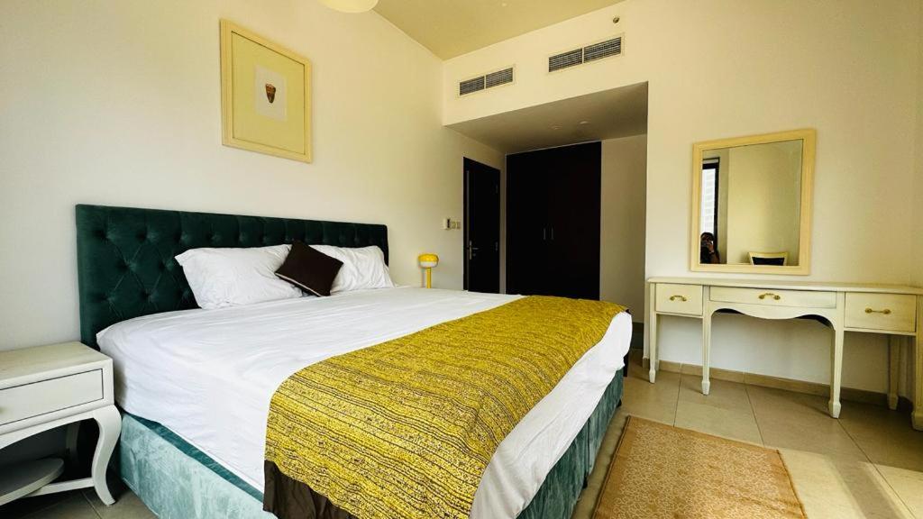 - une chambre avec un grand lit et une tête de lit verte dans l'établissement The Sand Castle - Bahar 6, The Walk at JBR, Near JBR Tram Station, à Dubaï