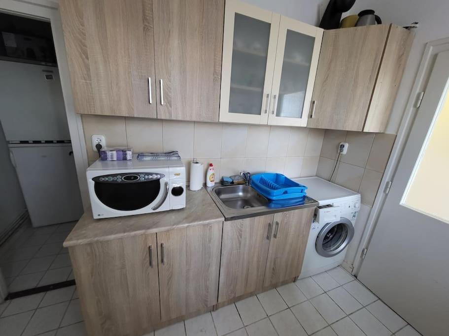 a small kitchen with a sink and a microwave at Wishy Washy House in Debrecen