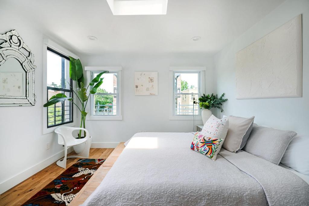 a white bedroom with a bed and windows at 3 BR 1 Bath Prime Williamsburg in Brooklyn