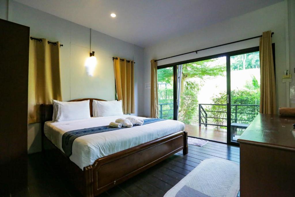 sypialnia z łóżkiem i przesuwnymi szklanymi drzwiami w obiekcie Plawan lipe Bungalows w mieście Ko Lipe