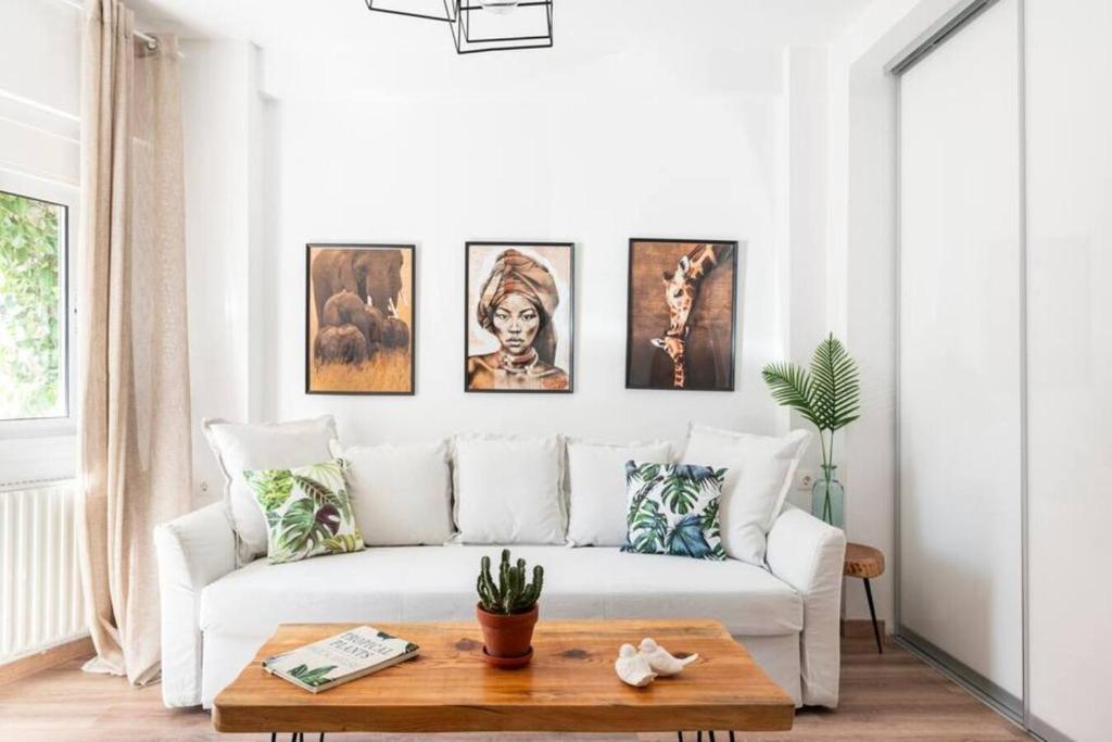 a living room with a white couch and pictures on the wall at Santa Triada in Heraklio