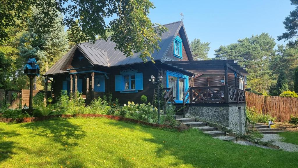 ein blaues Haus mit einem Garten davor in der Unterkunft Niezapominajka in Janówek Pierwszy