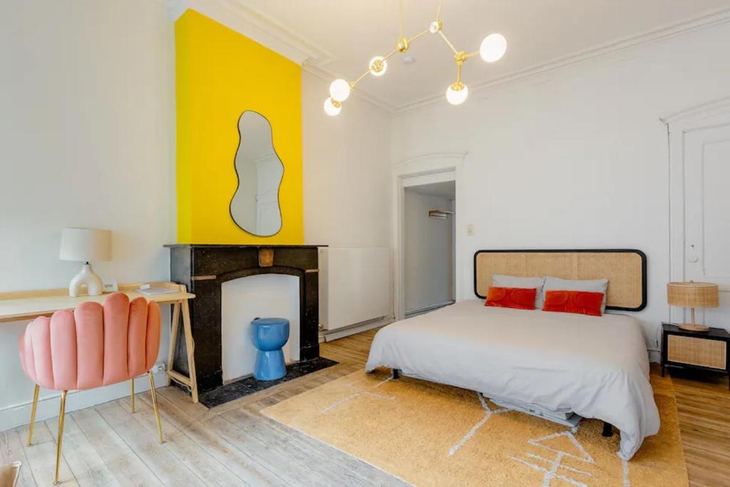 een slaapkamer met een bed en een open haard bij Le Studio en Feronstrée in Luik