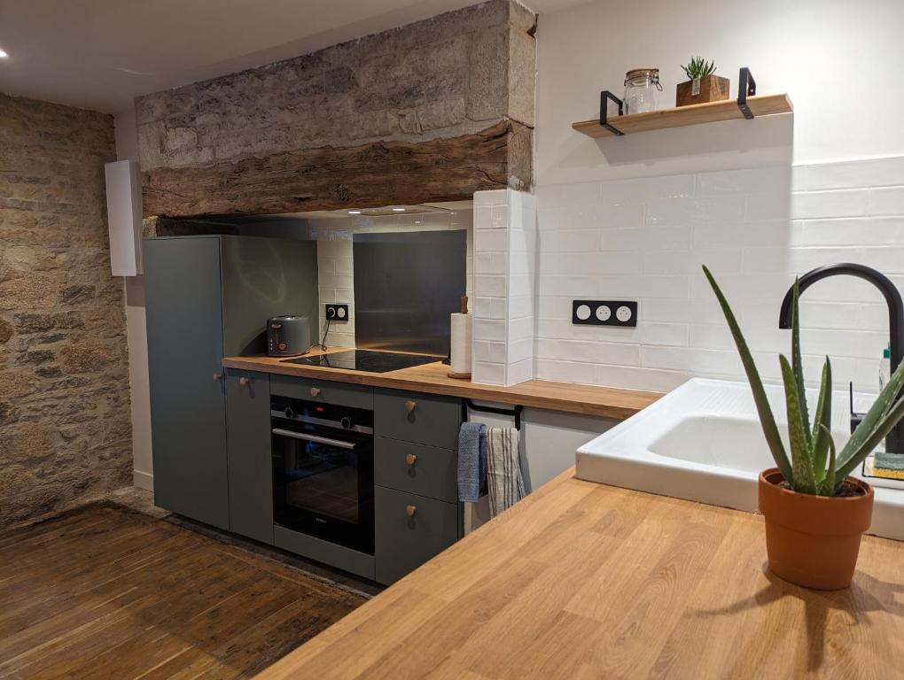 Il comprend une cuisine équipée d'une cuisinière, d'un évier et d'un comptoir. dans l'établissement Maison de Bourg Cressensac, à Cressensac