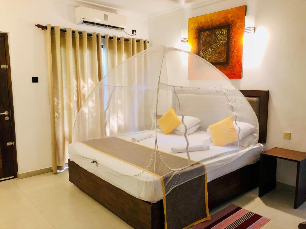 a bedroom with a bed with a mosquito net at Dambulla Rock Arch in Dambulla