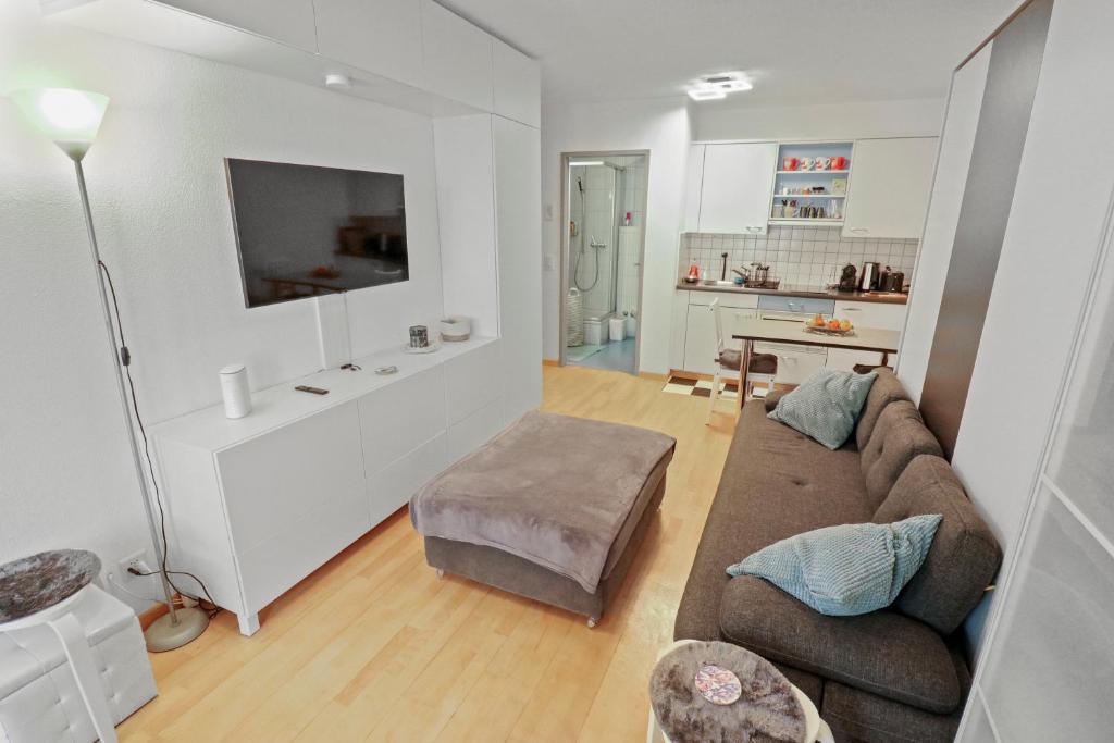 ein Wohnzimmer mit einem Sofa und einem TV in der Unterkunft Studio chaleureux avec vue sur les montagnes in Leukerbad