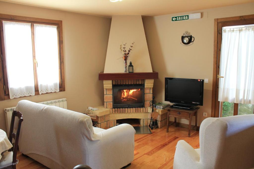 a living room with two chairs and a fireplace at Casa Rural Anie in Isaba