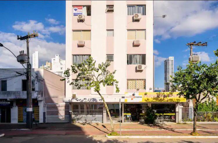 a large white building in front of a building at Residencial Primavera in Balneário Camboriú