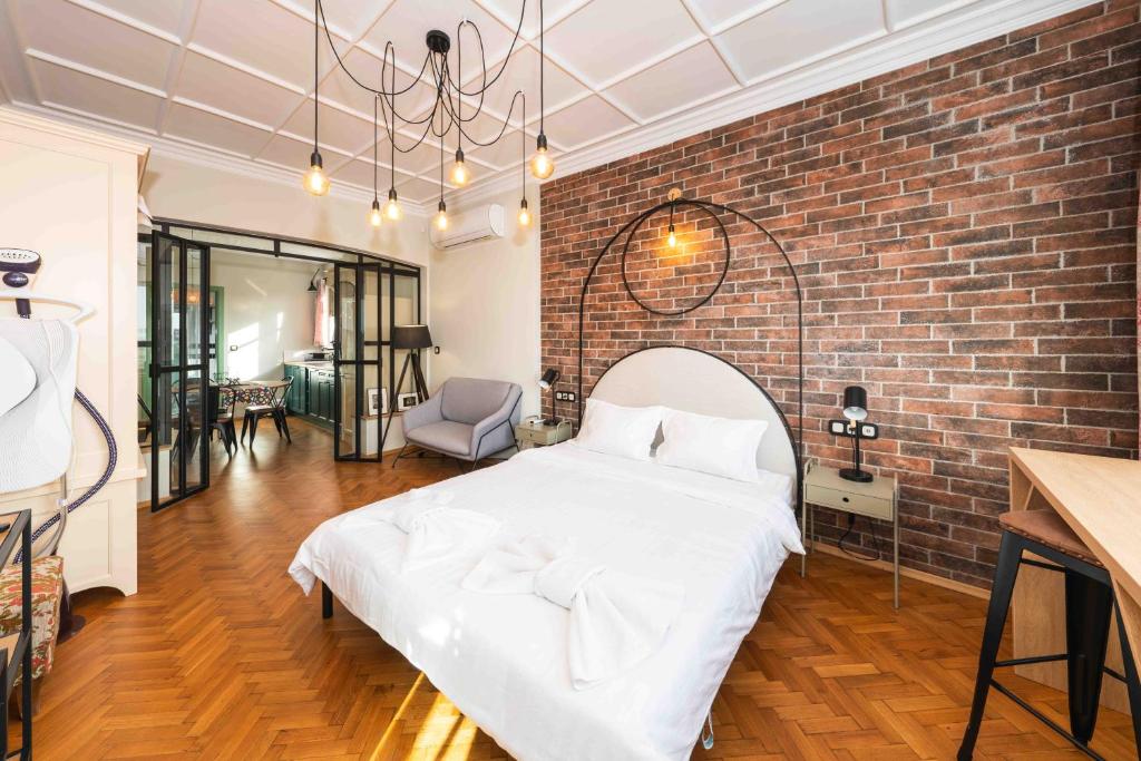 een slaapkamer met een wit bed en een bakstenen muur bij Heart of the City Center Lux Apartment with View in Sofia