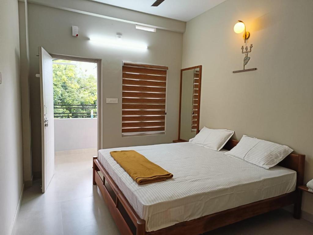 - une chambre avec un lit dans une pièce dotée d'une fenêtre dans l'établissement SN Residency, à Kalpatta