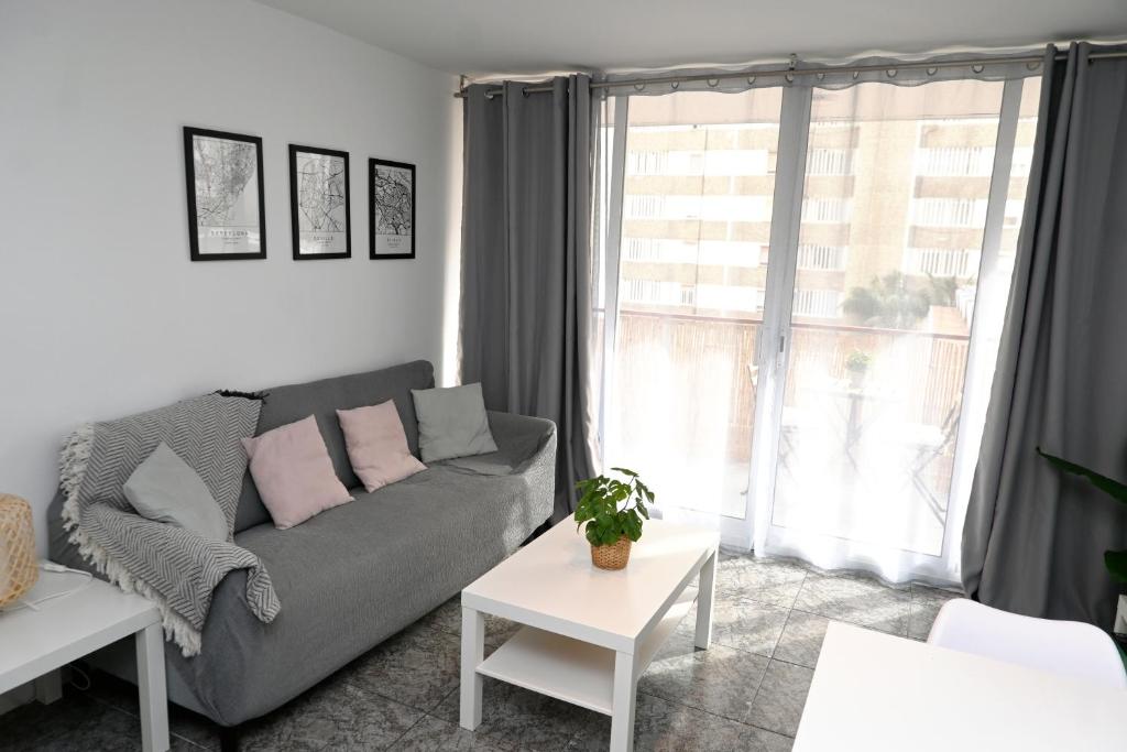 - un salon avec un canapé et une fenêtre dans l'établissement Homenfun Barcelona Bellvitge, à L'Hospitalet de Llobregat