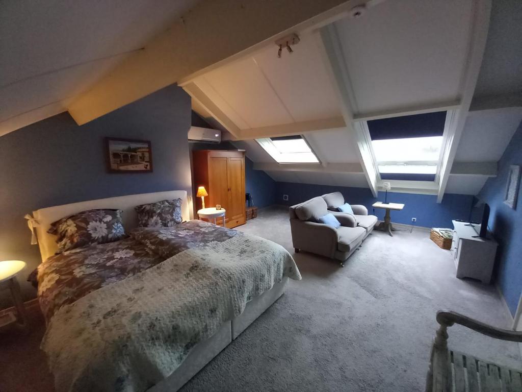 ein Schlafzimmer mit einem großen Bett und einem Sofa in der Unterkunft De Hagendoorn in Moorveld