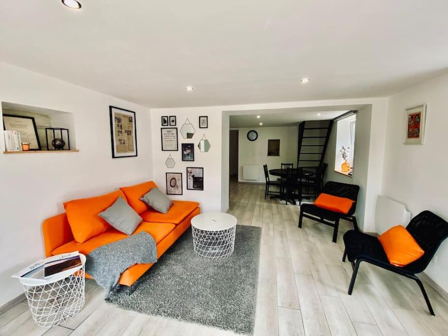 - un salon avec un canapé et des chaises orange dans l'établissement L'Écrivain, Vue lac, proche pistes de ski, à Gérardmer