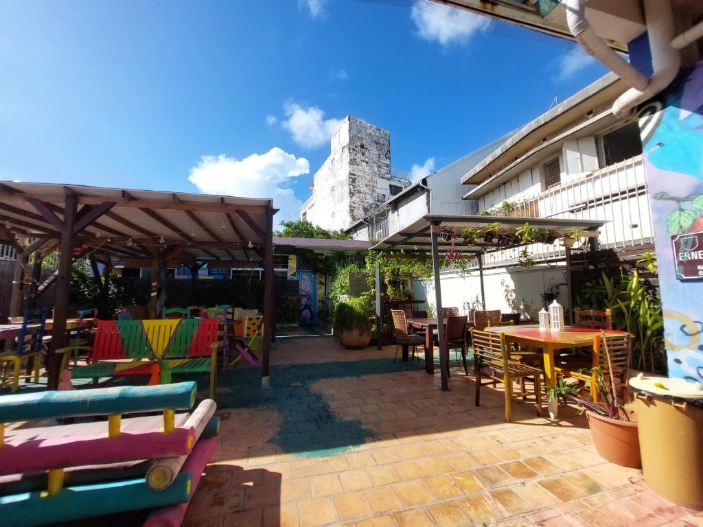 a patio with tables and chairs and a building at The GREEN Hostel in Pointe-à-Pitre