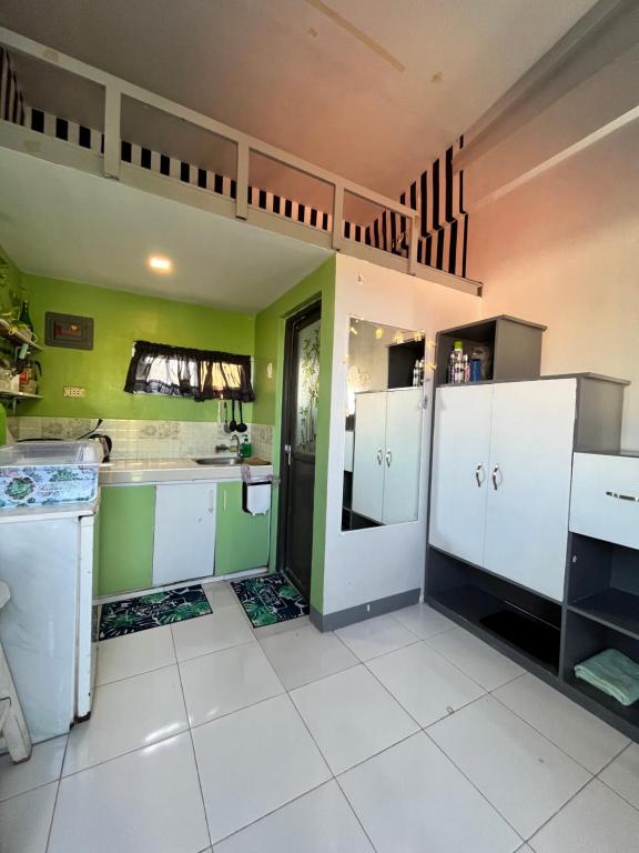 a kitchen with white cabinets and green walls at JC Unit #5 