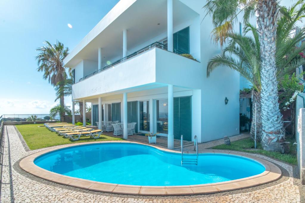 een villa met zwembad voor een gebouw bij Villa Amelia in Falésia by the Sea in Caniço