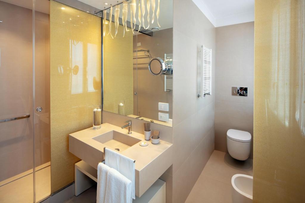 a bathroom with a sink and a toilet and a mirror at Palazzo Barocci in Venice