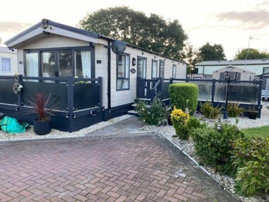 a mobile home with a patio and a driveway at 2 Bed, 2 Bath Lodge Style Caravan with Hot Tub & Private Garden in Patrington