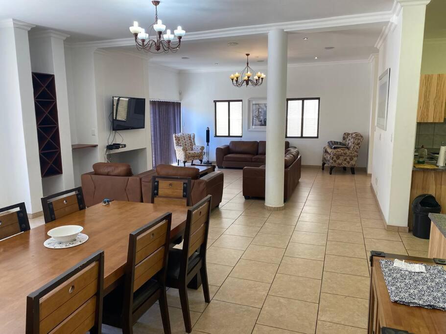 a dining room and living room with a table and couch at Langstrand Self Catering Villa - Sunset & Sunrise Rooftop including BBQ & Fireplace in Langstrand