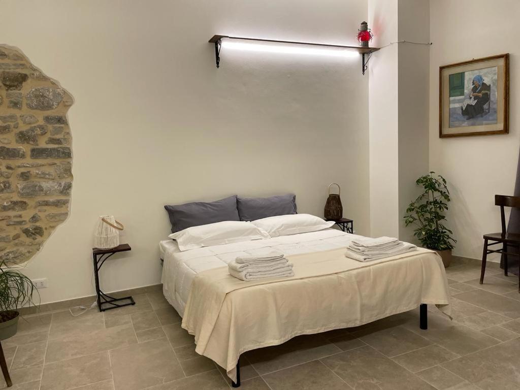 a bedroom with a large bed with white sheets at Baroon Bistrot & Rooms in Polizzi Generosa