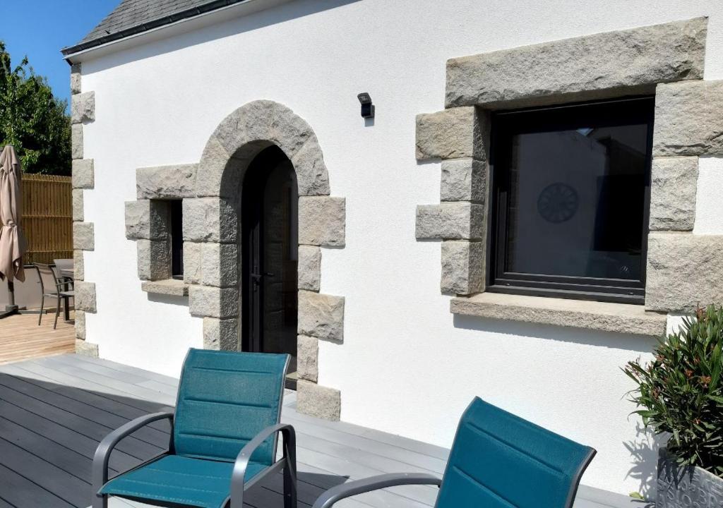 twee blauwe stoelen op een terras naast een gebouw bij Charmant Gîte à St-Cast in Saint-Cast-le-Guildo