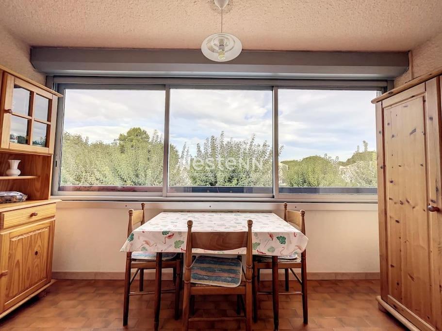 une salle à manger avec une table et une grande fenêtre dans l'établissement 3086-Appartement 2pièces bien situé, à Argelès-sur-Mer