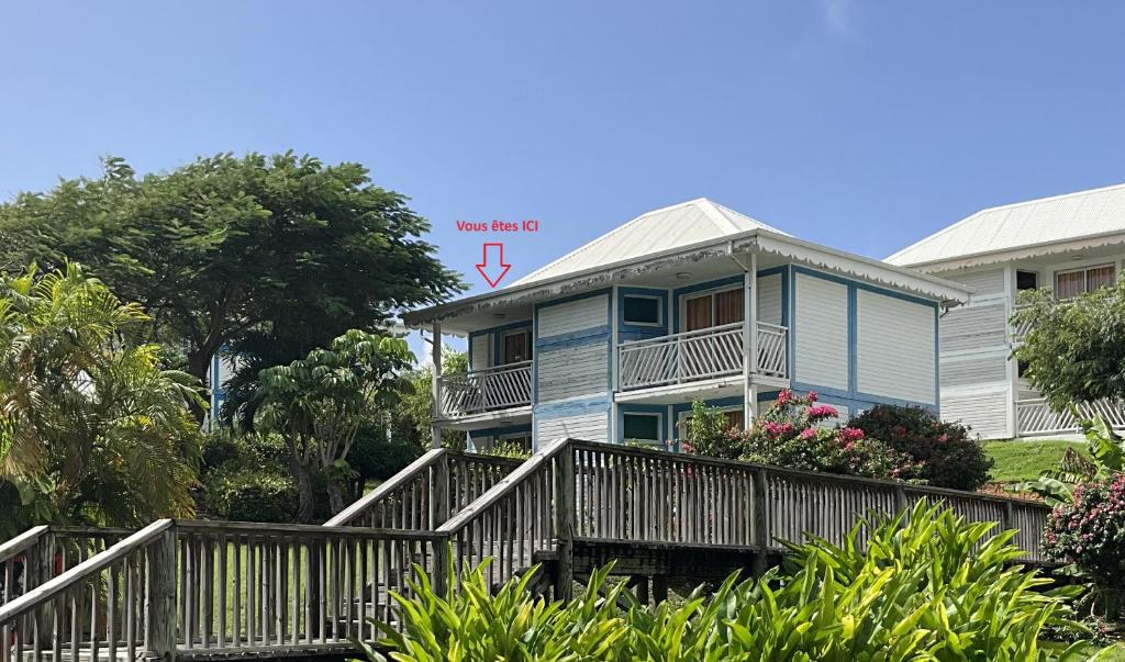 a blue house with a porch and a balcony at Good Mood Studio - Manganao Hôtel in Saint-François