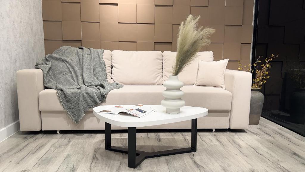 a living room with a white couch and a table at Brand New and Fully Furnished Apt in Buiucani in Chişinău