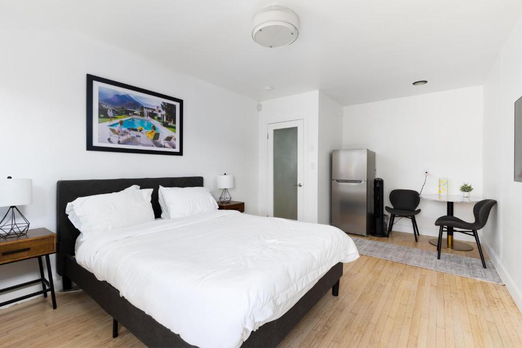 a bedroom with a large white bed and a refrigerator at Sunny Studio near Culver City in Los Angeles