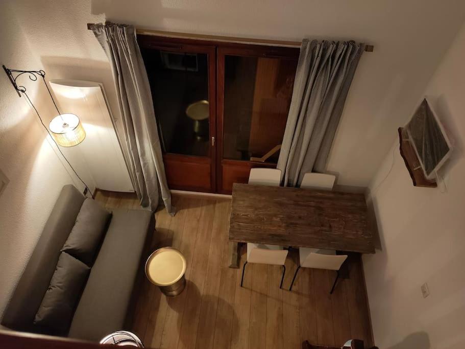 uma vista superior de uma sala de estar com uma mesa e cadeiras em Le Seignus: superbe studio avec vue sur les pistes em Allos