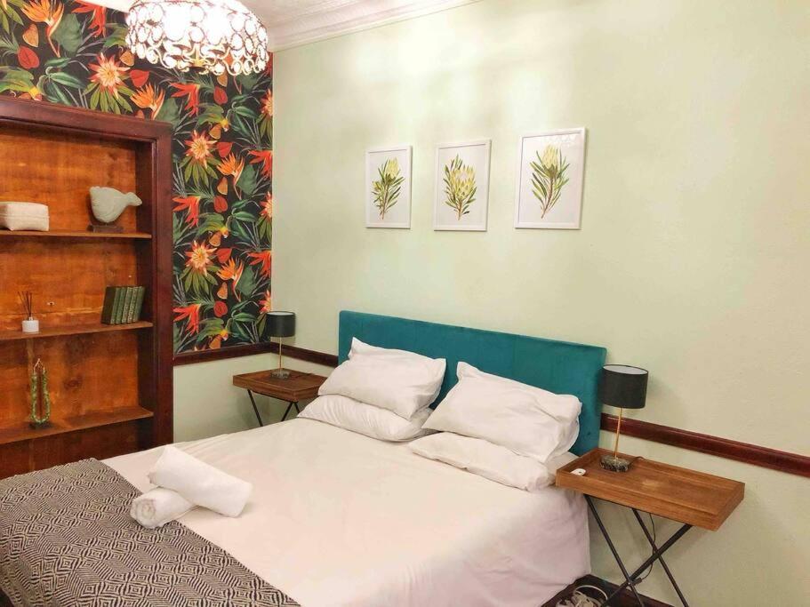 - une chambre avec un lit blanc et 2 tables dans l'établissement Cosy Bachelors, 2 min walk to Melville 7th, à Johannesbourg