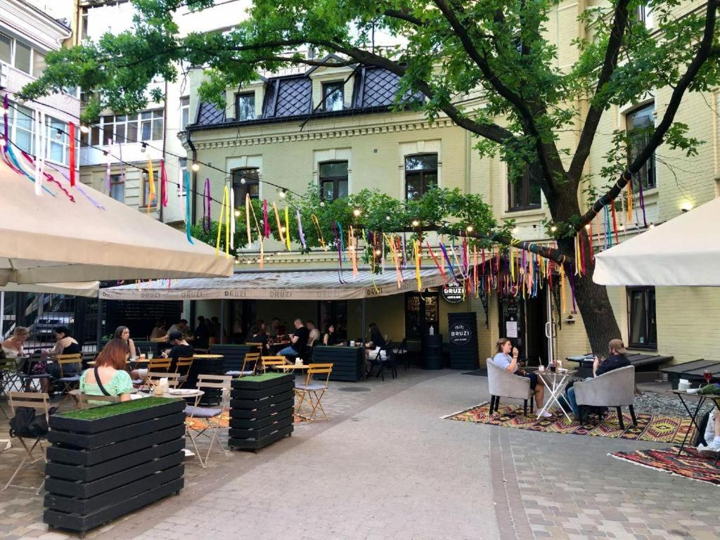 een groep mensen die aan tafels voor een gebouw zitten bij DREAM Hotel Kyiv in Kiev