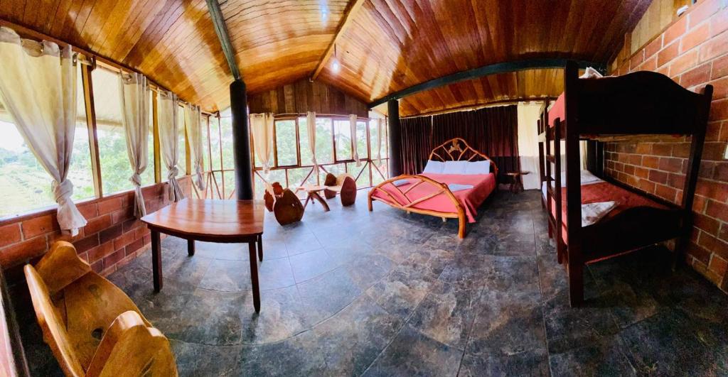 una habitación con una cama y una mesa en una casa en River Spot Lodge, en Tena
