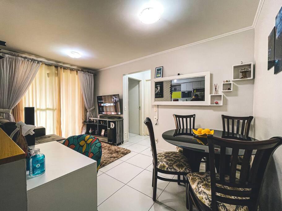 a kitchen and a living room with a table and chairs at Apartamento super agradável! Perto de tudo em Águas Claras in Brasilia
