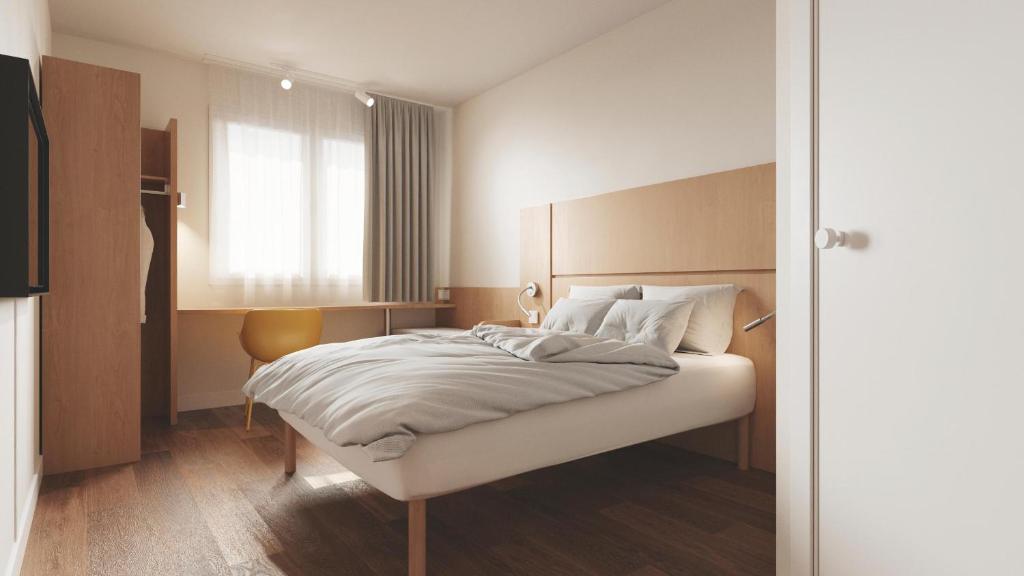 una camera con un letto bianco e una finestra di B&B HOTEL Kielce Centrum a Kielce