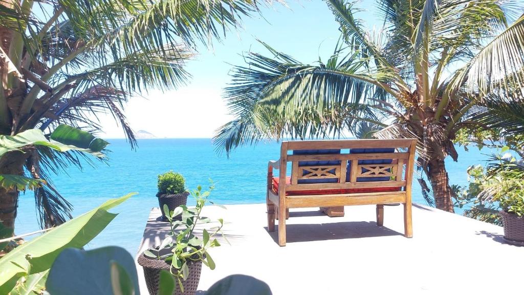 uma cadeira na praia com o oceano ao fundo em Lofts da Monica no Rio de Janeiro