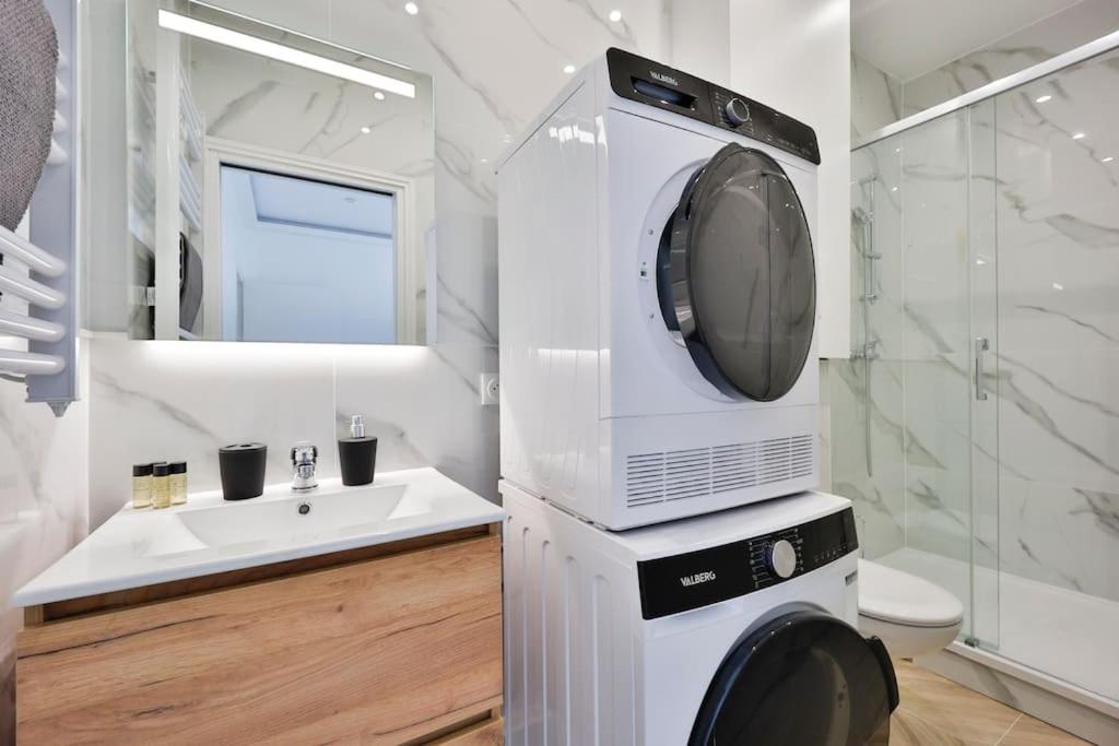 a bathroom with a washing machine and a sink at Le Joyau - App 4 personnes in Limeil-Brévannes