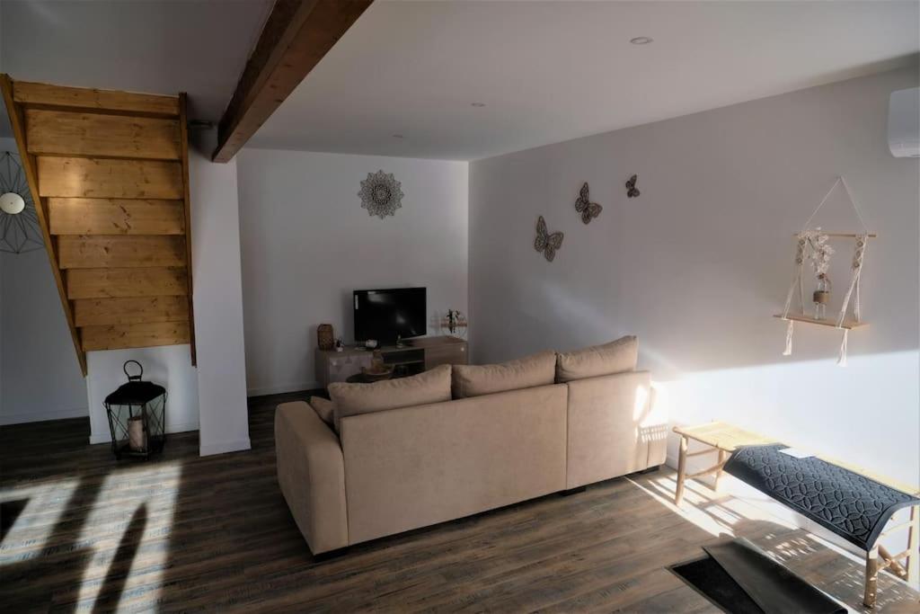 un salon avec un canapé et une télévision dans l'établissement Maison au cœur du Minervois, à Pouzols-Minervois