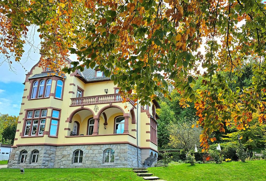 a large house on a field with trees at Hotel Erbprinzenpalais in Wernigerode