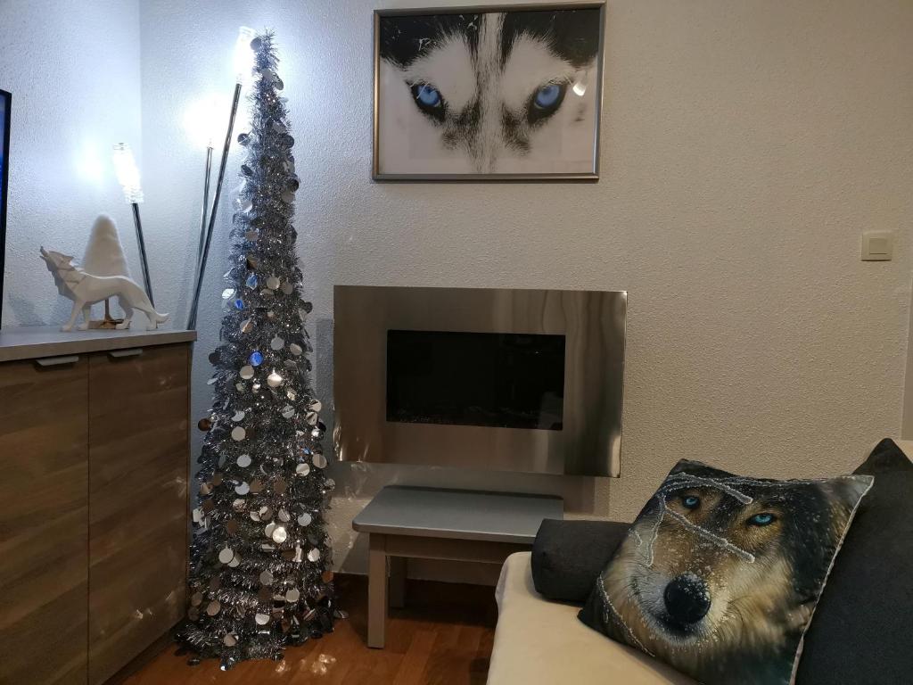 a living room with a christmas tree and a tv at Appartement "ENTOURLOUP" classé 2 étoiles in Le Dévoluy
