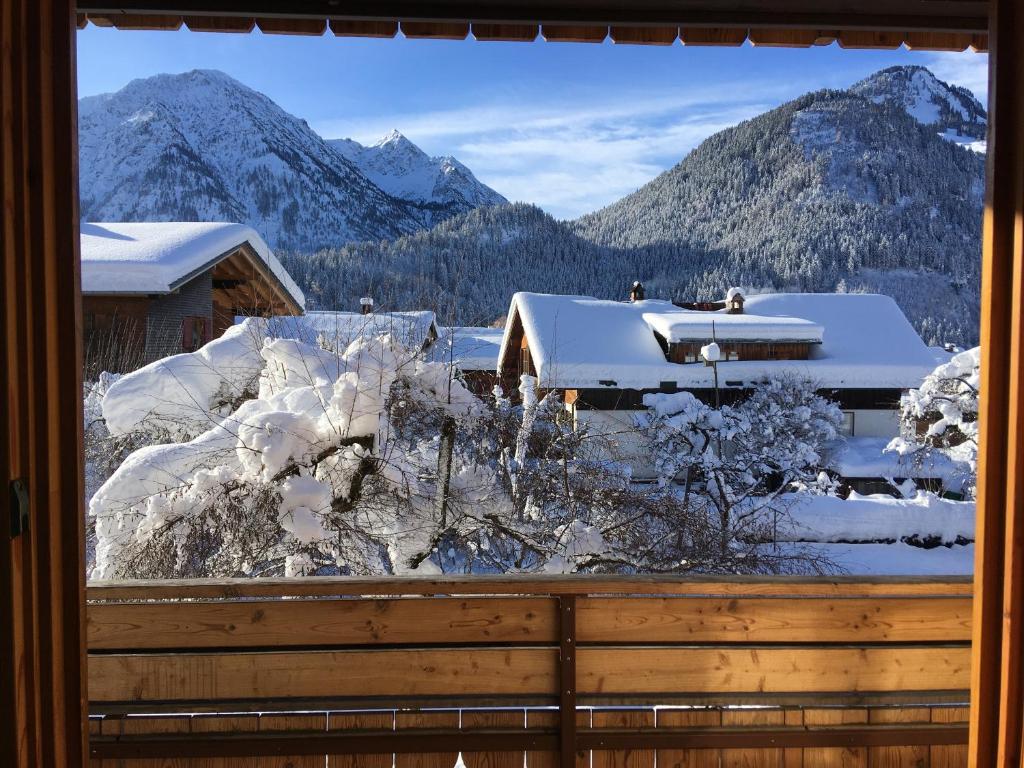 ein Fenster mit Blick auf die schneebedeckten Berge in der Unterkunft Haus Sonnenruh in Bad Hindelang